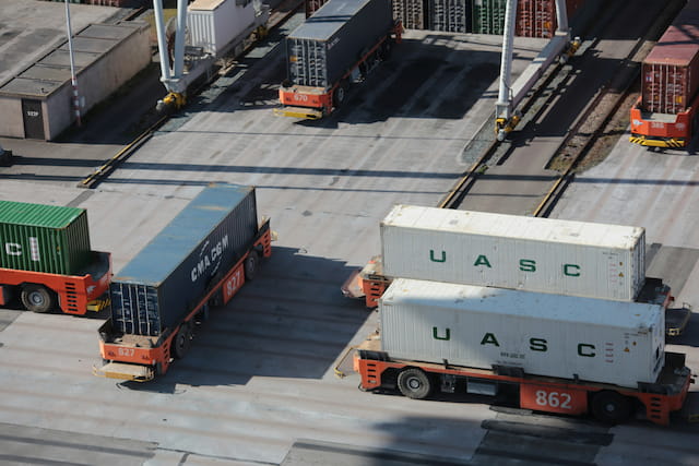 Automated yard vehicles moving containers in an industrial port environment